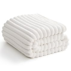 a stack of white towels stacked on top of each other in front of a white background