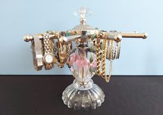 a glass vase filled with lots of jewelry