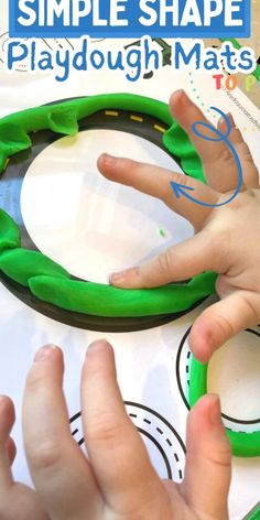 two hands are playing with playdough mats on the table while another hand is pointing at it