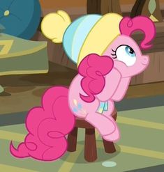 a pinkie pony sitting on top of a wooden bench