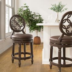 two brown stools sitting next to each other on top of a wooden floor