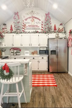 a kitchen decorated for christmas with red and white decorations on the ceiling, refrigerator, stove top oven, and counter