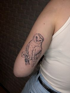 an owl tattoo on the left arm and shoulder is shown in black ink, with a small arrow at the bottom