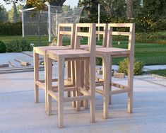 three wooden chairs sitting next to each other