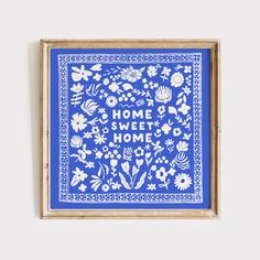 a blue and white framed artwork with the words home sweet home written in floral designs