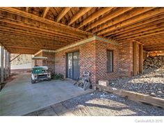 the back porch is covered with wood and has a tractor parked in front of it