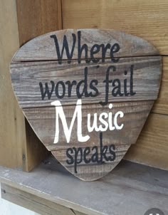 a wooden sign that says where words fail music speaks