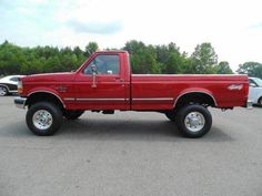 a red pick up truck parked in a parking lot