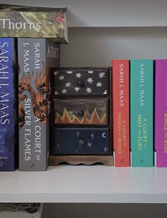 books are lined up on a white shelf