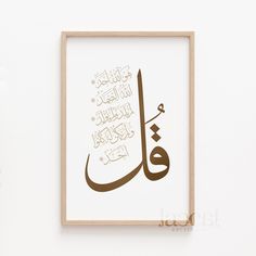 an arabic calligraphy is displayed on the wall in front of a white background with a wooden frame