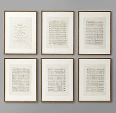 six framed music manuscripts in gold frames against a gray wall with white writing on them