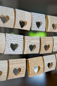 several pieces of paper with hearts cut out of them hanging from clothes pins on a string