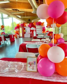 the tables are set up with red, white and orange balloons