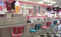 an ice cream shop with pink and blue chairs