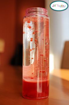 a jar filled with liquid sitting on top of a wooden table