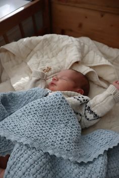 a baby is laying in a crib with a blanket on it's back