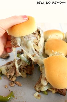 someone is taking a bite out of the pulled pork sliders with cheese and green peppers