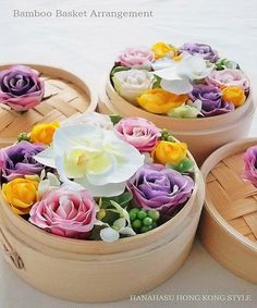 four wooden boxes with flowers in them on a table top and the words bamboo basket arrangement written below