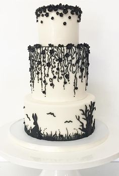 a three tiered cake decorated with black and white icing