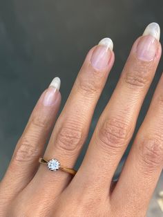 a woman's hand with a diamond ring on it