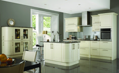 a modern kitchen with white cabinets and black counter tops, along with a dining room table