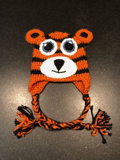 an orange and black knitted bear hat with big eyes on it's head