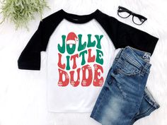 This trendy retro Christmas shirt is a must have for your Jolly Little Dude to rock this Christmas Holiday Season. Available in the black and white raglan shirt, or black or white tee shirt and bodysuits. ✨ HOW TO ORDER ✨ ✧ Select your options from the Drop Downs ✧ ADD TO CART • • • • • • • • • • • • • • • • • • • • • • • • • • • • • 👕 TOPS 👕 ✧Raglan shirt - soft black and white ✧Bodysuit - soft jersey rib knit bodysuit with envelop neck opening for easy on and off • • • • • • • • • • • • • • • • • • • • • • • • • • • • • 🎨 GRAPHIC DETAILS 🎨 ► Professional and Permanent Quality ► Vibrant and Accurate colors • • • • • • • • • • • • • • • • • • • • • • • • • • • • • 📋 CARE INSTRUCTIONS 📋 ✧ Wash Gentle ✧ No Bleach or Bleach Substitutes ✧ Hang to Dry for longevity ✧ Do not Iron Hipster Toddler Boy, Hipster Toddler, Toddler Christmas Shirt, Boys Christmas Shirt, Retro Christmas Shirt, White Tee Shirt, Raglan Shirt, Toddler Christmas, Knit Bodysuit