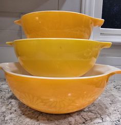 three yellow bowls stacked on top of each other