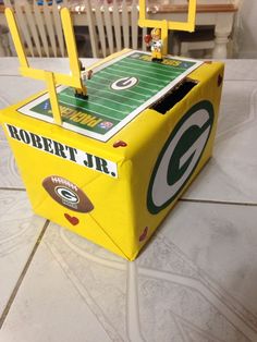 a green bay packers football game in a box on the floor with chairs around it