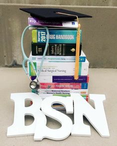 a stack of books with a stethoscope and graduation cap on top of them