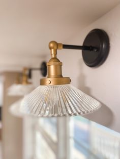 an old fashioned light fixture hanging from the ceiling in a room with white walls and windows