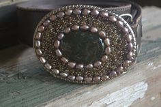 "This one of a kind beaded belt buckle measures 3 5/8\" x 2.5\" and fits 1 1/2\" snap belts. A variety of semi-precious and glass beads adorn this buckle. Sealed and water resistant with a high gloss resin. This buckle will add a touch of glamour and boho chic to any outfit. Custom designs available. Belt straps are sold separately." Elegant Handmade Adjustable Belt, Handmade Adjustable Belt Buckles As Gift, Elegant Handmade Belt Buckles As Gifts, Handmade Bohemian Belt Buckles As Gift, Handmade Artisan Belts For Gifts, Handmade Artisan Belt As Gift, Beaded Belt, Green Agate, Amber Color