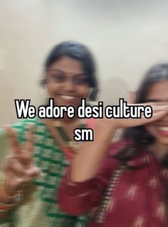 two women are smiling and making the peace sign with their hands in front of them