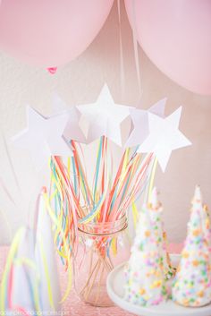 there are balloons and cake pops in the jar on the table with other decorations around it