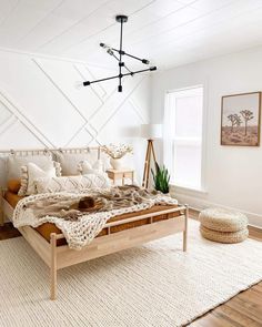 a bedroom with white walls and wood furniture, including a large bed in the center