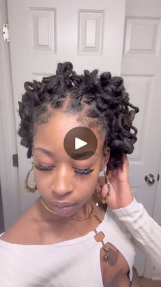 a woman with an afro braid is looking at the camera and has her hand on her head