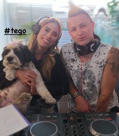 a man and woman are posing for a photo with a dog in front of them