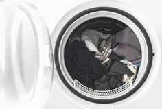 an open washing machine with clothes in it