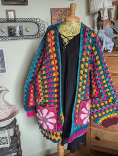 Crochet Granny Square Hexagon Cardigan is exactly what you need in your fall wardrobe. Not only will it keep you warm it will have heads turning and people asking you "where did you get it" and you and you alone will reply " oh it's one of a kind" 😉 The pockets are made with 3D 70's inspired daisy that gives the cardigan it's unique finish. It  approximately measures 27" wide About 34 long Arms 16 1/2 It fits medium to  3X etsy.com/ CA/ shop/ cherylshearthome Pink Hexagon Cardigan, Retro Hand Knitted Long Sleeve Cardigan, Retro Hand-knitted Long Sleeve Cardigan, Cozy Patchwork Cardigan, Cozy Long Sleeve Granny Square Cardigan, Crochet Grandma Square, Crochet Grandma, Crochet Granny Square Cardigan, Granny Square Hexagon