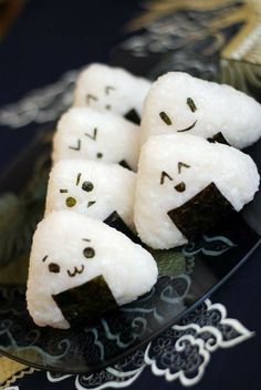 some kind of food that is on a plate with chopsticks in the shape of ghost faces