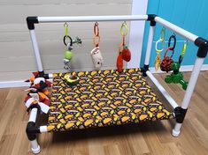 a child's bed with toys hanging from the rails and on the floor next to it