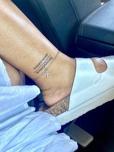 a woman's foot with a cross tattoo on her left ankle, sitting in a car