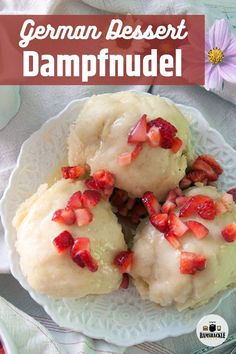 german dessert dumplings with strawberries and cream on a white plate next to a pink flower