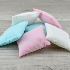 four pillows stacked on top of each other in pastel blue, pink and white