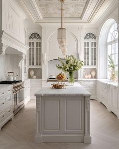 a large kitchen with white cabinets and an island in front of the stove top oven