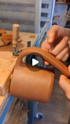 a person is holding a leather bag and using scissors to cut the handle on it