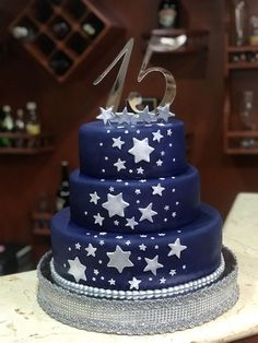 a blue cake with white stars and the number twenty five on it's top