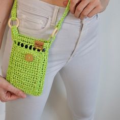 a woman holding a green crocheted purse