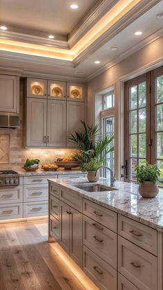 a large kitchen with wooden floors and white cabinetry is lit by recessed lighting