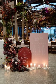 a table with candles and flowers on it next to a sign that says the couple is married